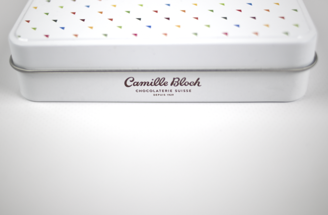 Photographie d'un côté de la boîte de chocolat où figure le logo de Camille Bloch