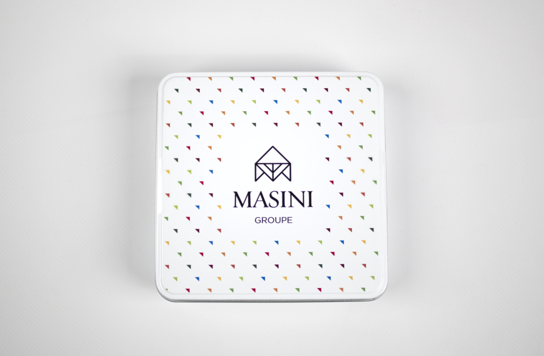 Photographie vue du dessus de la boîte de chocolats présentant le logo de Masini Groupe et le motif en triangle